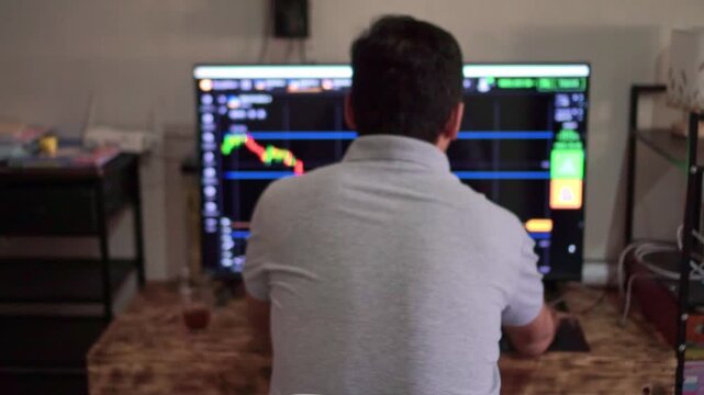 Man from behind studying stock candlestick chart, trading interface with buy sell options, market analysis and investment strategy concept.