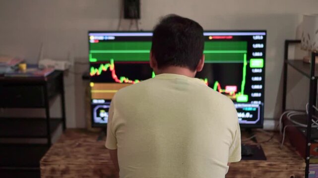 Focused trader watching live market chart on large screen, financial trading platform with price data, investment analysis and stock market concept.