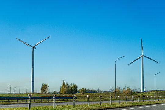 Modern wind turbines of a wind farm producing clean renewable energy under a clear blue sky.