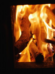 Fototapeta premium Fire is burning in a fireplace, with the flames reaching up to the ceiling