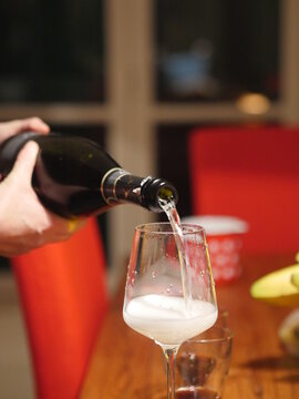 Person is pouring champagne into a wine glass