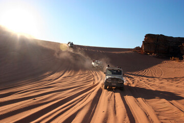 Wadi Rum desert, Jordan – off-road vehicles crossing sunlit sand dunes during the day in the vast arid landscape of the Middle East © ClearPix Media