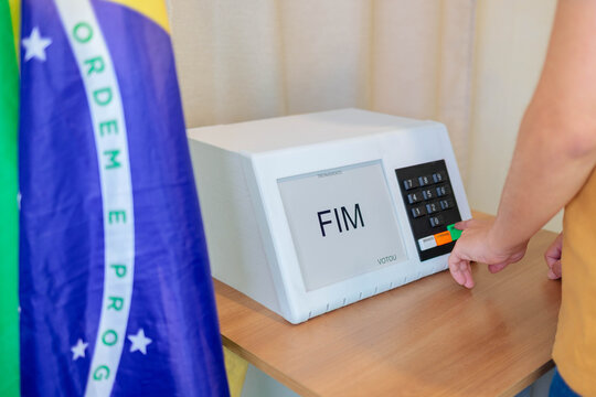 M&atilde;o de eleitor confirma o voto na urna eletr&ocirc;nica, com a tela exibindo "FIM", durante as elei&ccedil;&otilde;es presidenciais brasileiras de outubro.
