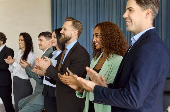 Audience professionals applaud at seminar workshop. Smiling executives and employees clapping to honor achievement, showing team recognition and applause. Team recognition and business success.