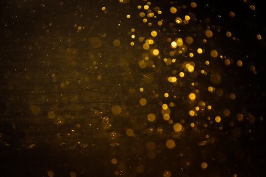 Blurred photo with golden dots visible glittering, shining brightly look and feel luxurious Suitable for use as a wallpaper
