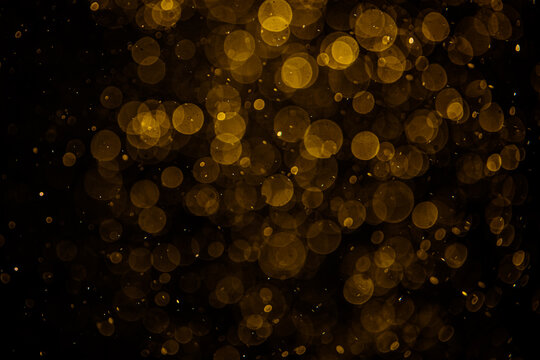 Blurred photo with golden dots visible glittering, shining brightly look and feel luxurious