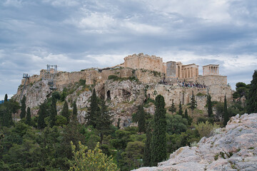 Fototapeta premium Wide-angle view of the Acropolis hill and Propylaea viewed from Areopagus Hill under a dramatic sky.