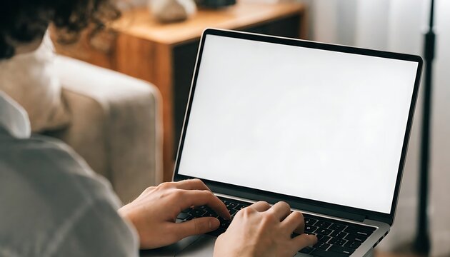 Person working on a laptop with a blank white screen for mockup design and digital content.