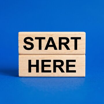 Wooden blocks with the text Start Here on a vibrant blue background