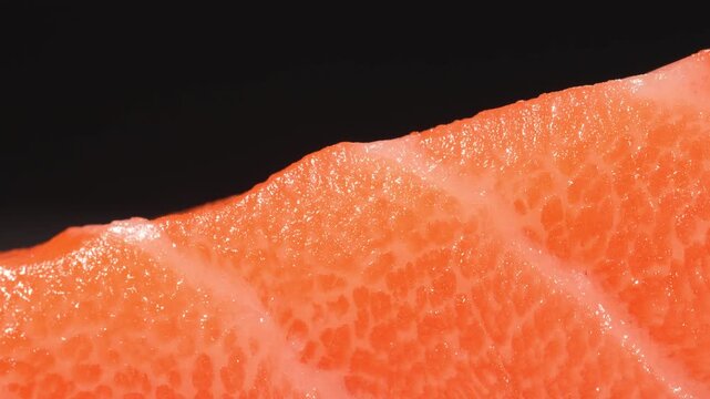Extreme macro dolly shot of fresh raw salmon fillet highlighting detailed meat texture and fat layers.