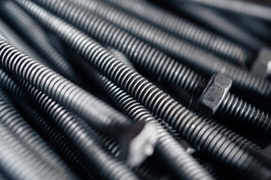 Industrial Steel Bolts and Screws Lying in a Pile in a Workshop Setting for Manufacturing and Engineering Concept with selective focus 
