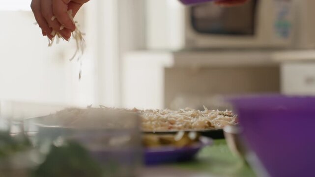 Low-angle close-up of hand scattering topping over homemade pie resting on wire cooling rack, with falling crumbs, warm sunlight, soft blur, and gentle kitchen motion after baking, with hand