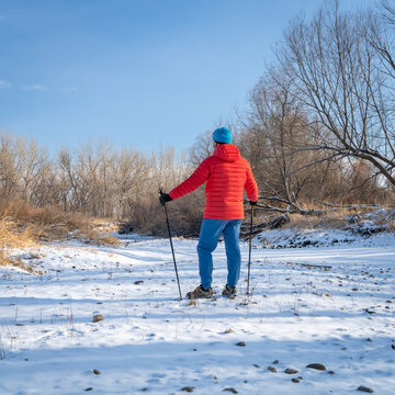 senior man is Nordic walking  along the Poudre River in Colorado, cold winter scenery