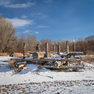 log erosion control structure on a shore of the Poudre River in Fort Collins, Colorado in winter scenery