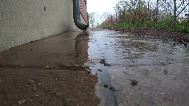 Rainwater flowing beside house wall and downspout