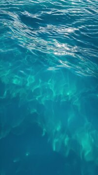 Vertical blue ocean waves with bright sunlit caustics. Seamless loop for phone backgrounds, reels, and marine motion graphics. Vertical 3d render video.