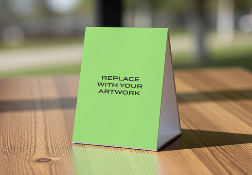 Table tent sign mockup on a wooden surface with natural light, realistic stationery branding presentation for business, advertising, or event display, template artwork replacement