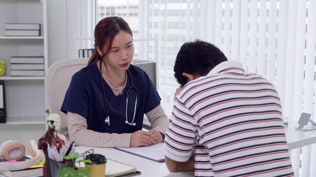 Young Asian female doctor comforting distressed patient during medical consultation in bright modern clinic office