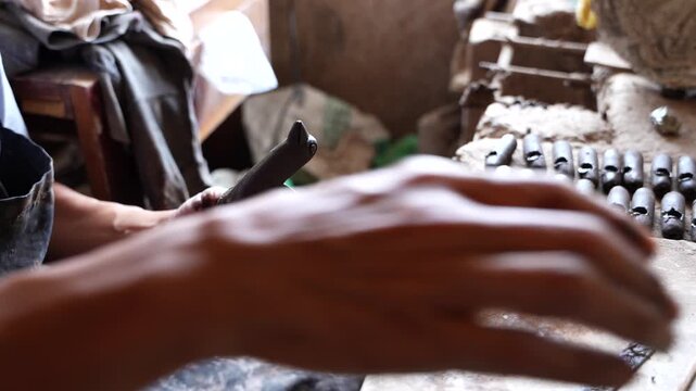 Potter hands creating traditional black pottery whistle