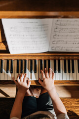 childs hands playing on piano keys © Jenisse