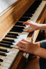 childs hands playing on piano keys © Jenisse