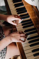 childs hands playing on piano keys © Jenisse