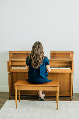 Woman playing sheet music on a piano © Jenisse