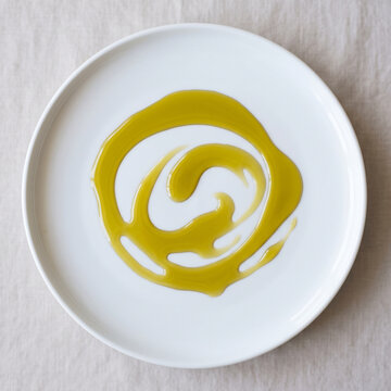 Assiette blanche avec spirale d&rsquo;huile d&rsquo;olive sur lin