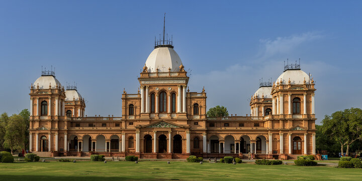 View of the historic Noor Mahal palace with its distinctive domes and arches set against a clear blue sky in Bahawalpur, Punjab, Pakistan.