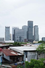 Fototapeta premium Urban cityscape with modern high-rise buildings contrast with urban neighborhoods 