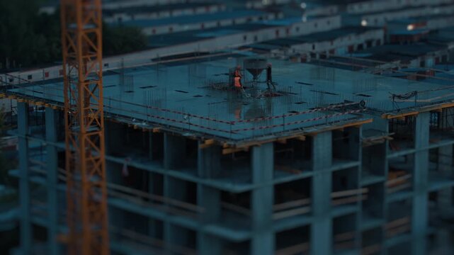 Day to night timelapse of the workers working with liquid concrete on the constriction site of the living building in a city