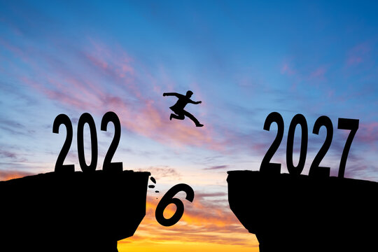 Silhouette man jump between 2026 and 2027 years with sunset background, Success new year concept.