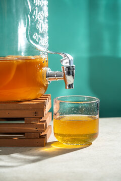 Homemade kombucha tea in a glass dispenser with scoby