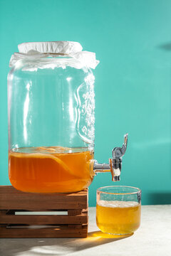 Homemade kombucha tea in a glass dispenser with scoby