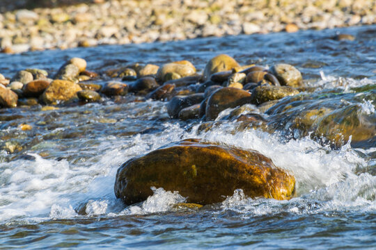 Murti river in the morning, riverbed in foreground with flowing water and stones. Scenic beauty of Dooars landscape, West Bengal, India