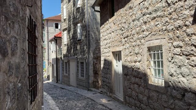 Narrow cobblestone street in an old European town, historic architecture and authentic urban atmosphere on a sunny summer day