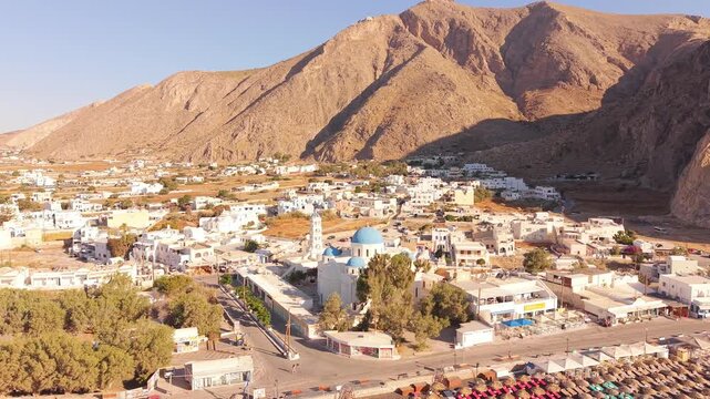 Drone shot of Perissa village center featuring Perissa Beach Kiosk church surrounded by white buildings Santorini