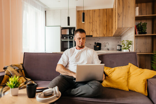 Man use laptop for remote work on home sofa