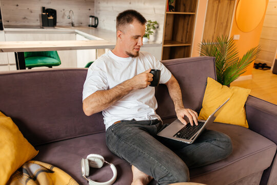 Man work remotely on laptop from home with coffee