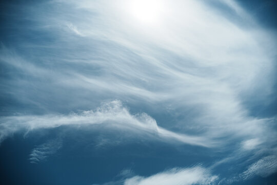 View of wispy cirrus clouds drifting across a deep blue sky with bright sunlight in Hayama, Kanagawa, Japan.