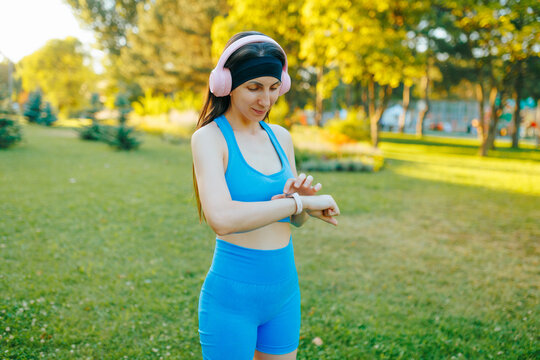 Fit young athlete setting her smartwatch before outdoor fitness workout.