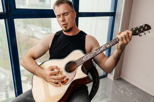 Man play guitar and sing on balcony