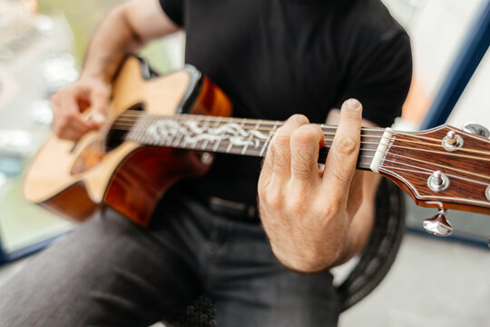 Man play acoustic guitar on balcony during leisure time