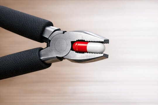 Close-up view of a pair of pliers lying on a wooden surface