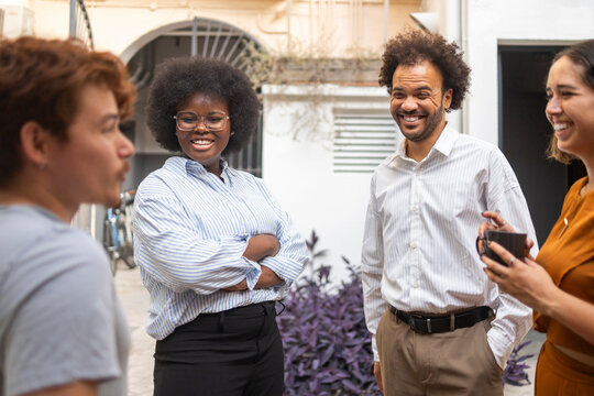 Diverse coworking team socializing during office break