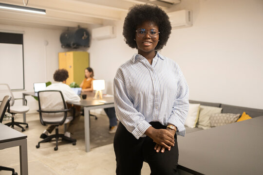 Smiling businesswoman in coworking office with team members