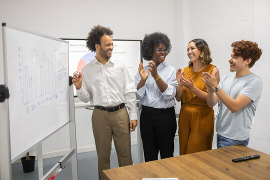 Diverse coworking team applaud presentation in modern office