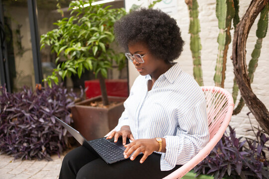 Woman working on laptop in a coworking garden office