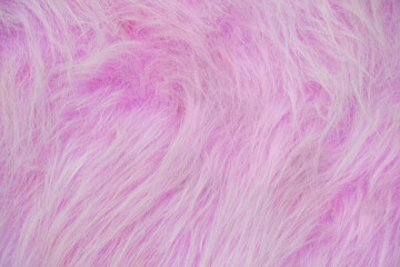 Fototapeta premium Pink Faux Fur Surface Displayed Closeup Showing Soft Long Fibers And Fluffy Texture For Fabric Or Textile Backdrop.