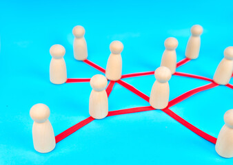 Obraz premium Wooden people connected through red lines showing teamwork and communication network on turquoise background 